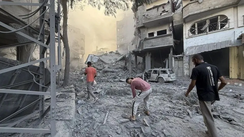 Varios hombres caminan por los escombros tras uno de los ataques lanzados por Israel en Gaza. EFE