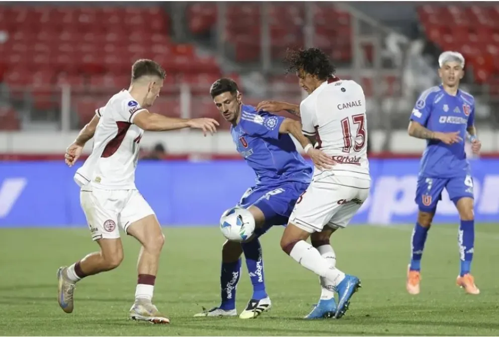 Un juego muy parejo se vio entre la U de Chile (de azul) y Lanús. Foto: EFE.