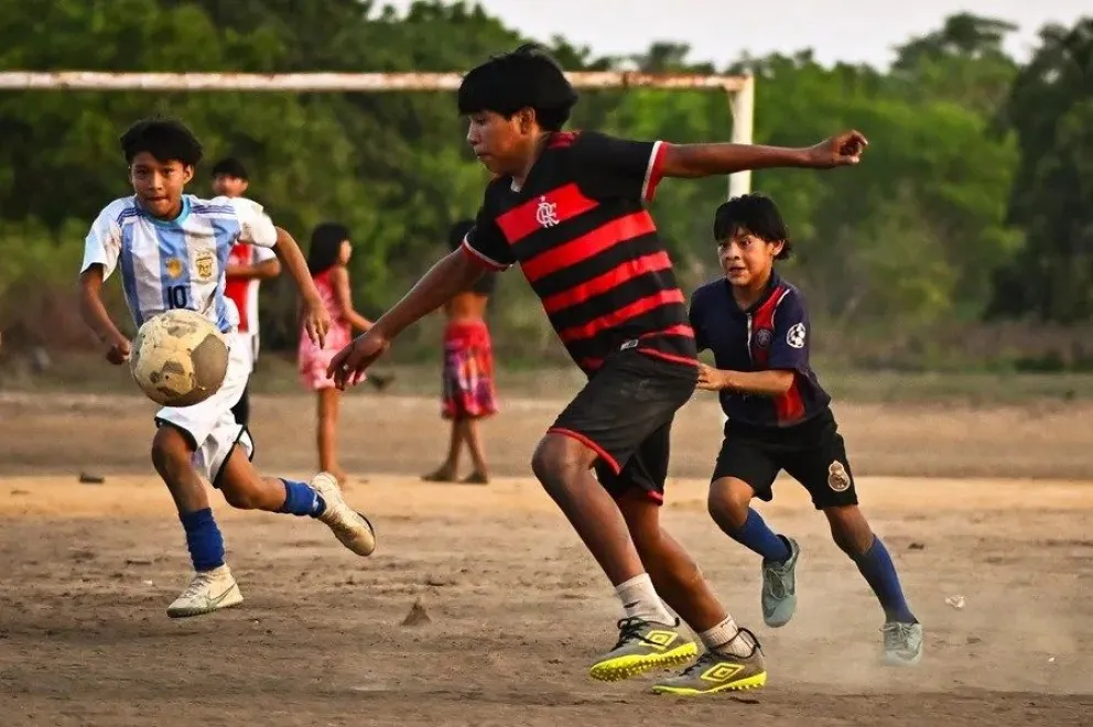 Fotografía de niños indígenas jugando fútbol en la Aldea Kamayurá, en el Parque Indígena Xingu, estado de Mato Grosso (Brasil). EFE