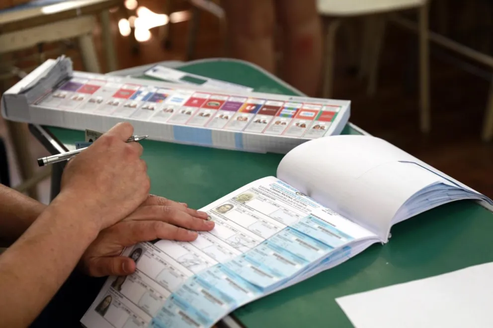 Un jurado revisa la lista de votantes en una mesa en Buenos Aires. Foto: EFE