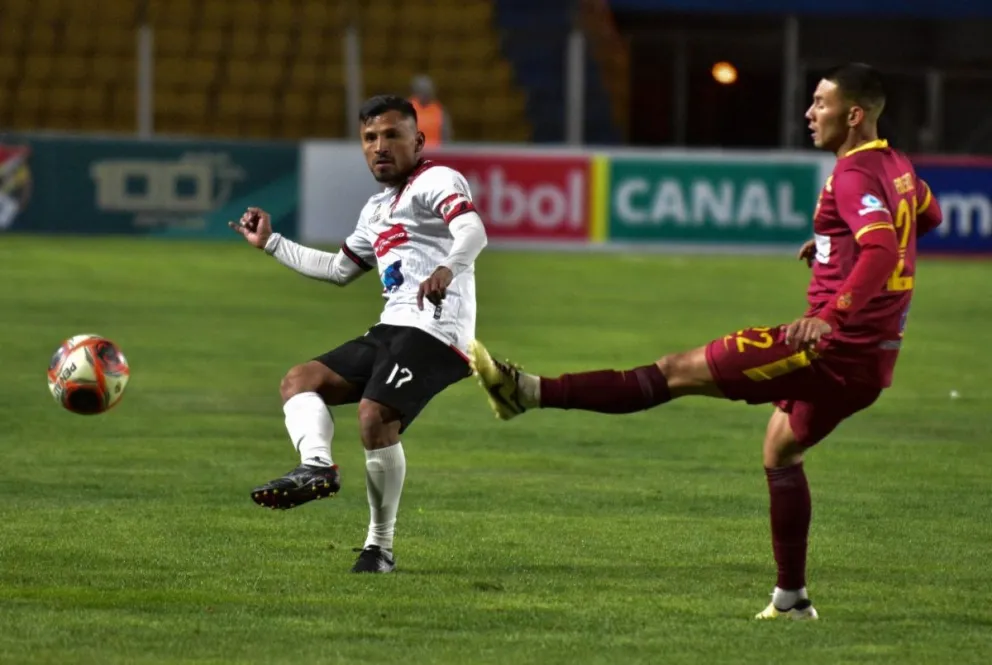 Saulo Guerra (izq.), de Nacional, remata al arco marcado por Carlos Ribera de Real Oruro. Foto: APG