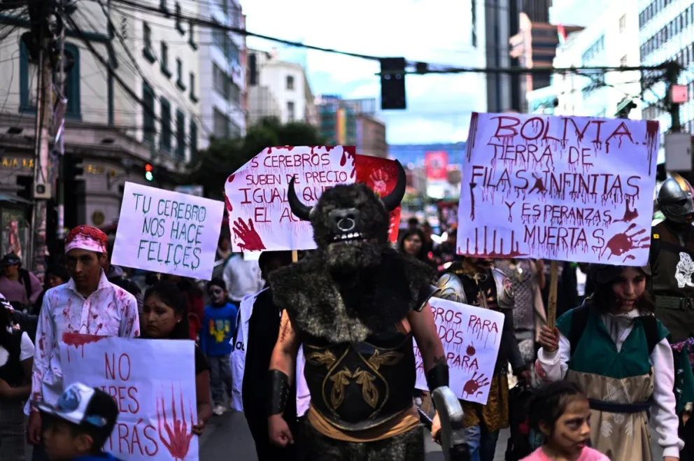 Jóvenes disfrazados portan pancartas con frases relacionadas a la crisis en Bolivia. Foto: Ricardo Carvallo 