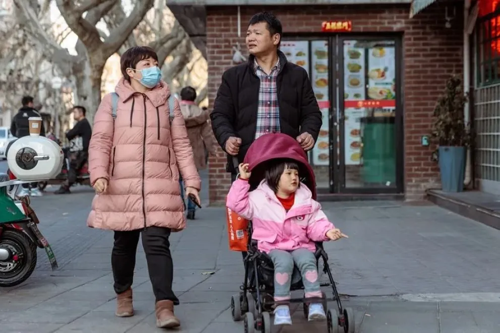 Una familia camina por la calle en Shanghái, China. Foto: EFE