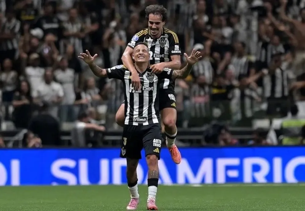 Guilherme Arana, con los brazos abiertos, y uno de sus compañeros celebran el primer gol del Mineiro. Foto: EFE