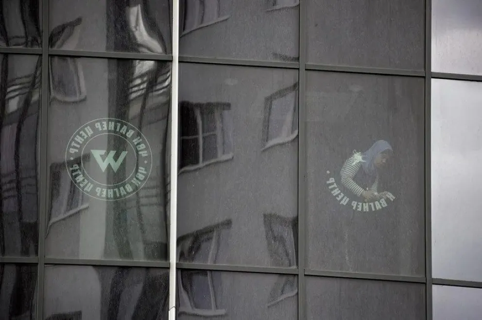 Un trabajador retira el logotipo de la compañía militar privada Grupo Wagner, de la ventana de un edificio. EFE