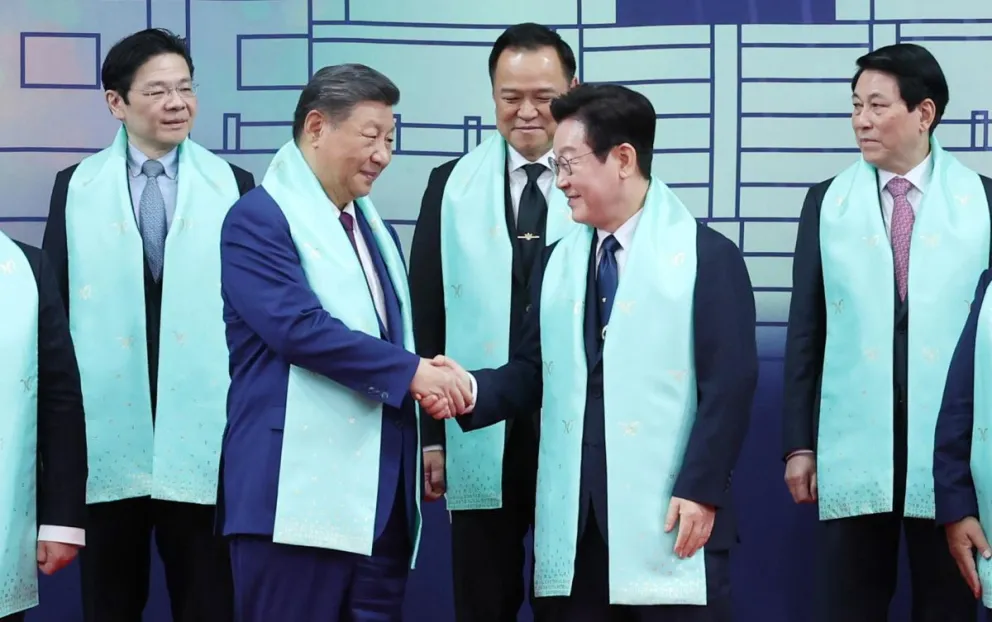El presidente surcoreano, Lee Jae Myung (D), estrecha la mano con el presidente chino, Xi Jinping, durante la foto del grupo en la cumbre del foro de Cooperación Económica de Asia-Pacífico (APEC), celebrada en la localidad de Gyeongju, (Corea del Sur) EFE