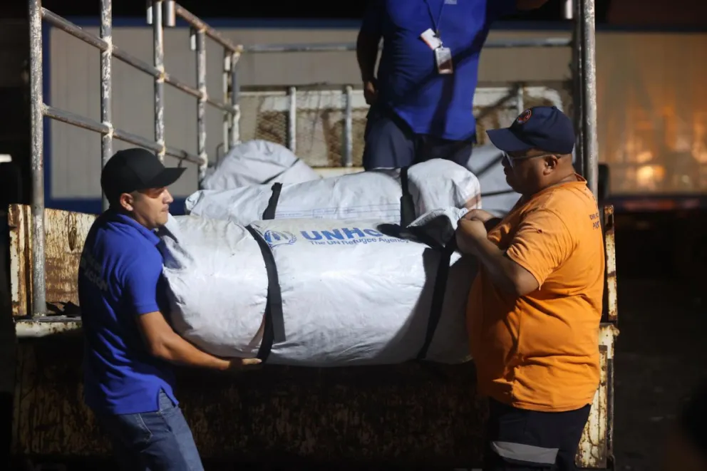 Integrantes del Ministerio de Gobernación preparan ayuda humanitaria este viernes, en el aeropuerto internacional Óscar Arnulfo Romero, en San Luis Talpa (El Salvador). Foto: EFE