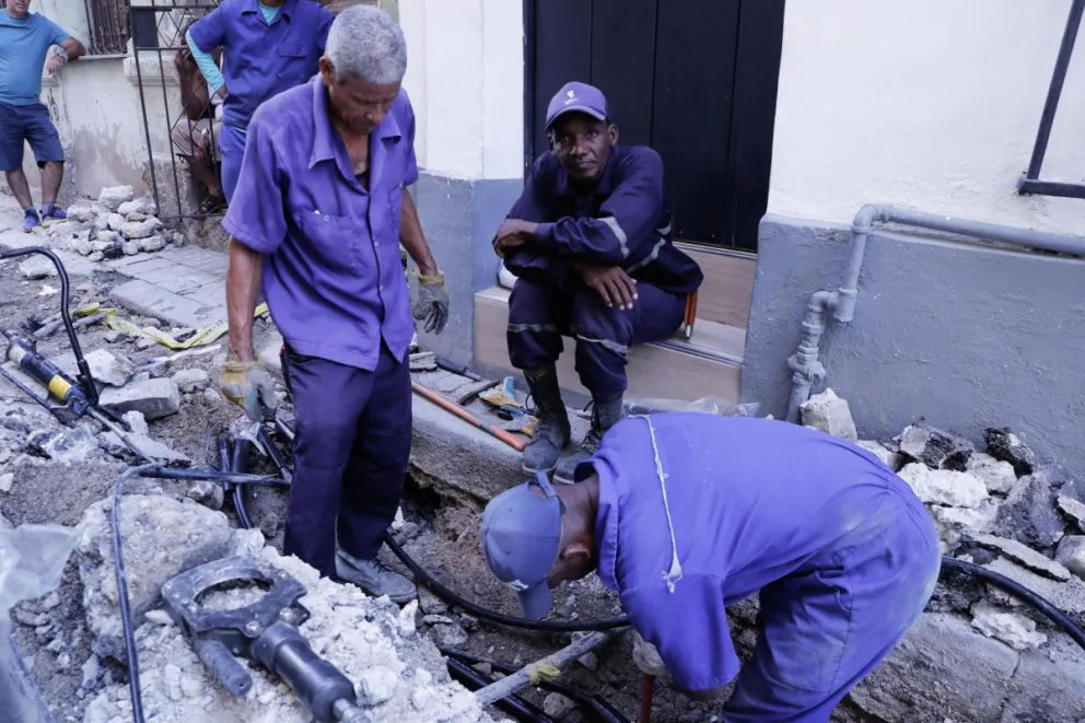 Fotografía de archivo, tomada el pasado 8 de octubre, de un grupo de empleados estatales al trabajar en el arreglo de una línea eléctrica, en La Habana (Cuba). Foto: EFE