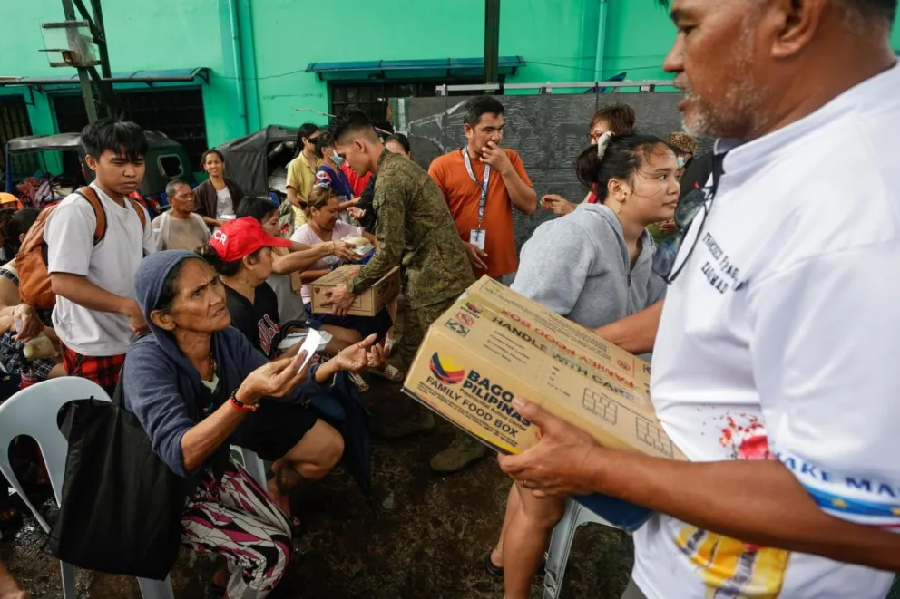 Familias de uno de los distritos costeros, afectados por el tifón Fung-Wong, esperan recibir paquetes de ayuda en Manila. Foto: EFE 