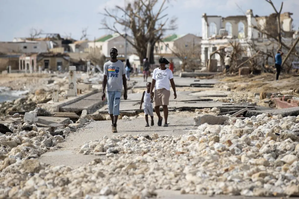 Una familia camina por una calle azotada por el huracán Melissa. / Foto: EFE. 