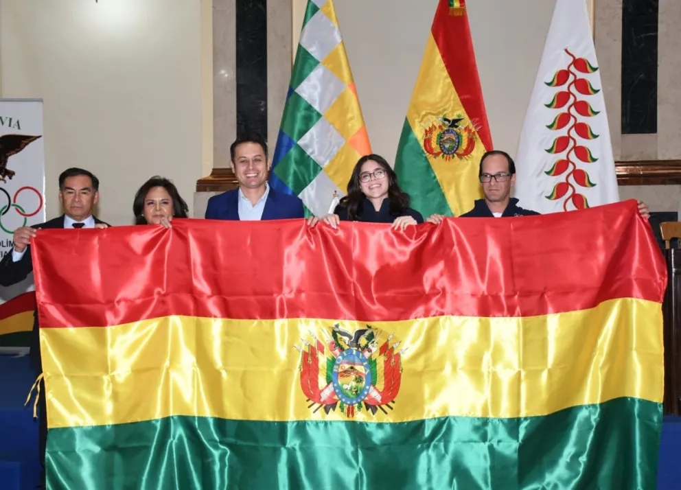 A la derecha Giles y Canelas junto al Vicepresidente Edman Lara que entregó la bandera boliviana. Foto: Marka Registrada