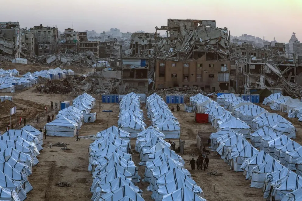 Palestinos desplazados caminan entre refugios improvisados ​​erectos junto a los restos de edificios destruidos en la ciudad de Gaza Norte. Foto: EFE