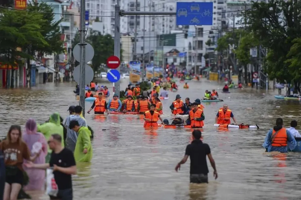 Personas caminan entre las aguas de las inundaciones en Nha Trang, provincia de Khanh Hoa. Foto: EFE