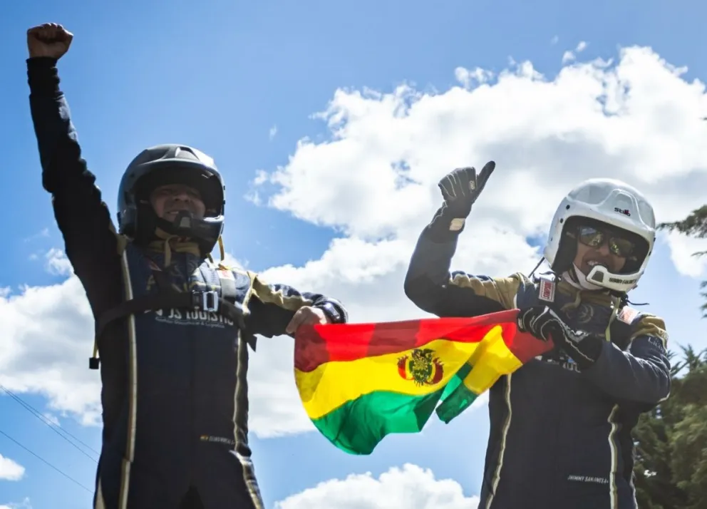 Sanjinéz (der.) junto a su navegante Roncal y la tricolor nacional tras asegurarse el título sudamericano. Foto: Codasur.