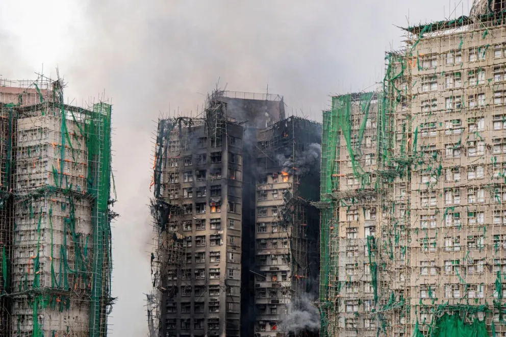 Una nube de humo sale desde uno de los edificios calcinados en Hong Kong. Foto: EFE