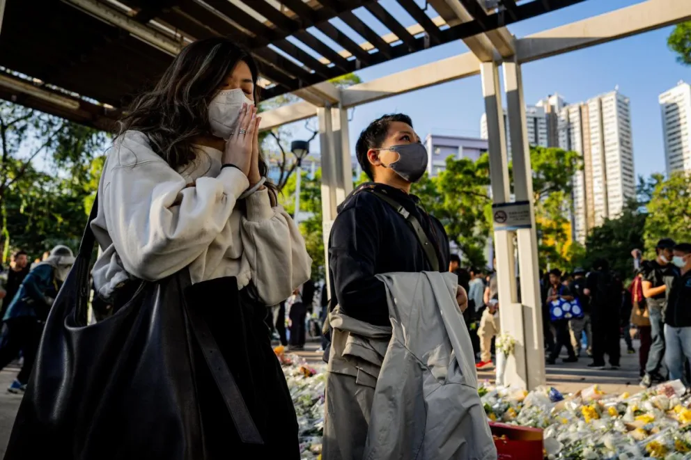 Personas rezan por las víctimas del incendio en el complejo residencial Wang Fuk Court en el distrito de Tai Po en Hong Kong, China. Foto: EFE