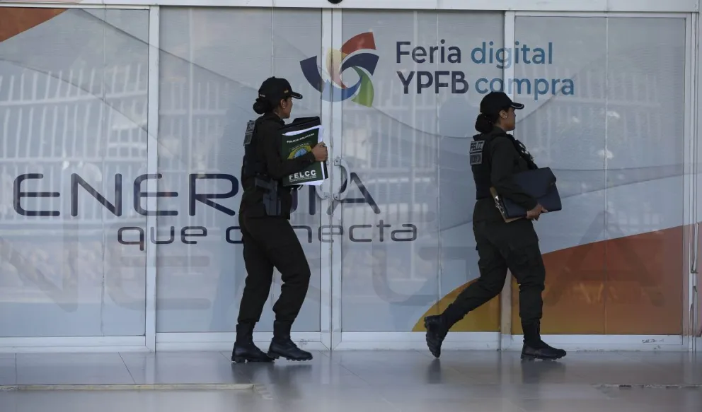 Dos policías transportan documentos secuestrados. FOTO: APG