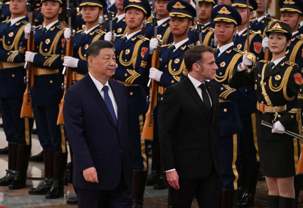 El presidente de China, Xi Jinping, y su homólogo de Francia, Emmanuel Macron, caminan frente a la guardia de honor en Pekín,