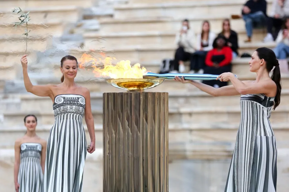La actriz griega Mary Mina, en el papel de la Suma Sacerdotisa, enciende la Antorcha Olímpica en la ceremonia de este jueves. Foto: EFE