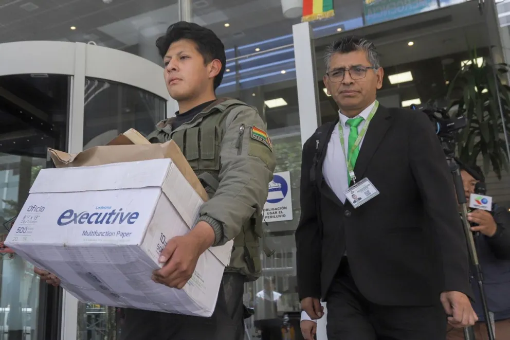 Funcionarios de la Fiscalía y de la Policía boliviana salen de las oficinas de Yacimientos Petrolíferos Fiscales Bolivianos (YPFB) luego de una intervención este 5 de diciembre de 2025, en La Paz. Foto: EFE