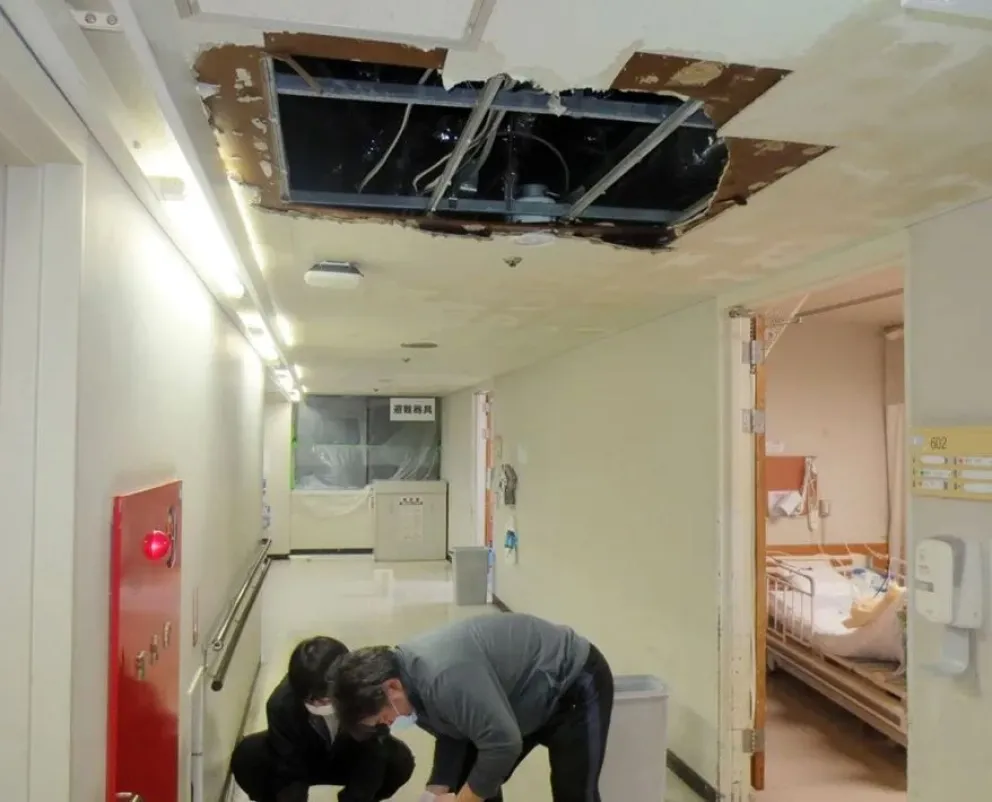 Personas limpian el techo de un hospital que resultó afectado en el terremoto. Foto: EFE