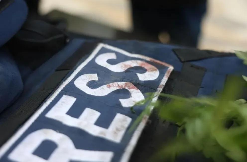 Manchas de sangre en el chaleco de prensa de un periodista. Foto: EFE