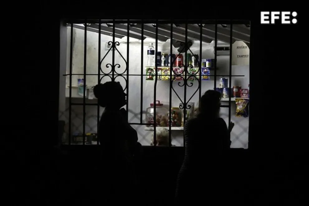 Personas compran en una tienda durante un corte eléctrico en La Habana. Foto: EFE