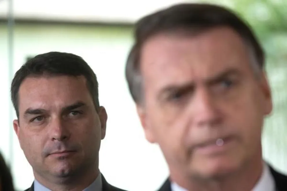 Foto de archivo de julio de 2018 del senador electo Flavio Bolsonaro (i), hijo del expresidente de Brasil, Jair Bolsonaro (d), escucha a su padre durante una rueda de prensa en Brasilia (Brasil). EFE/Joédson Alves