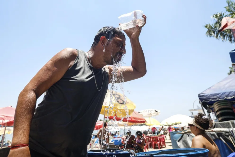 Un hombre se refresca con agua en la playa del lago artificial 'Piscinão de Ramos' este viernes, en Río de Janeiro (Brasil). Foto: EFE