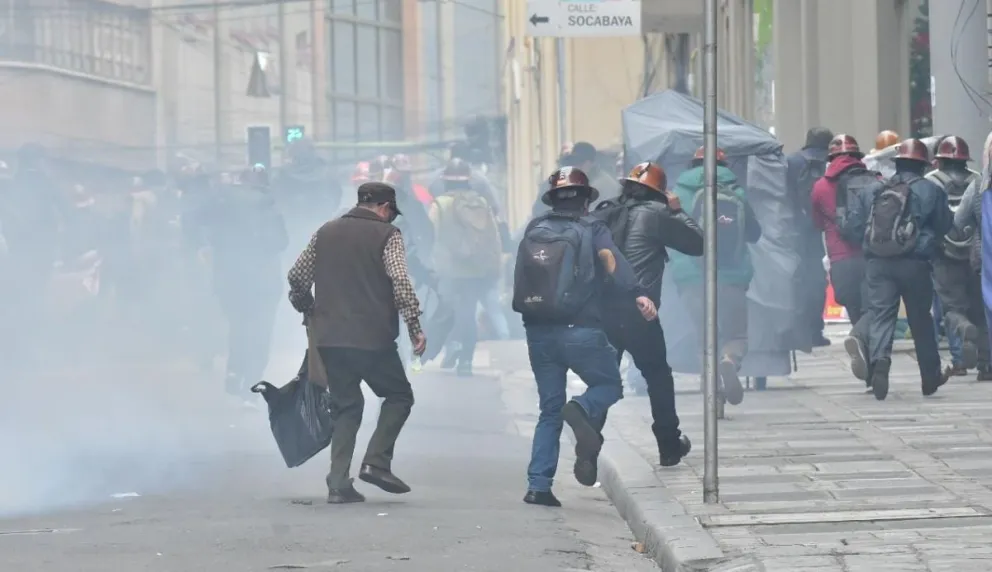 Un grupo de mineros corre tras alertar sobre la detonación de un cachorro de dinamita. Foto: APG