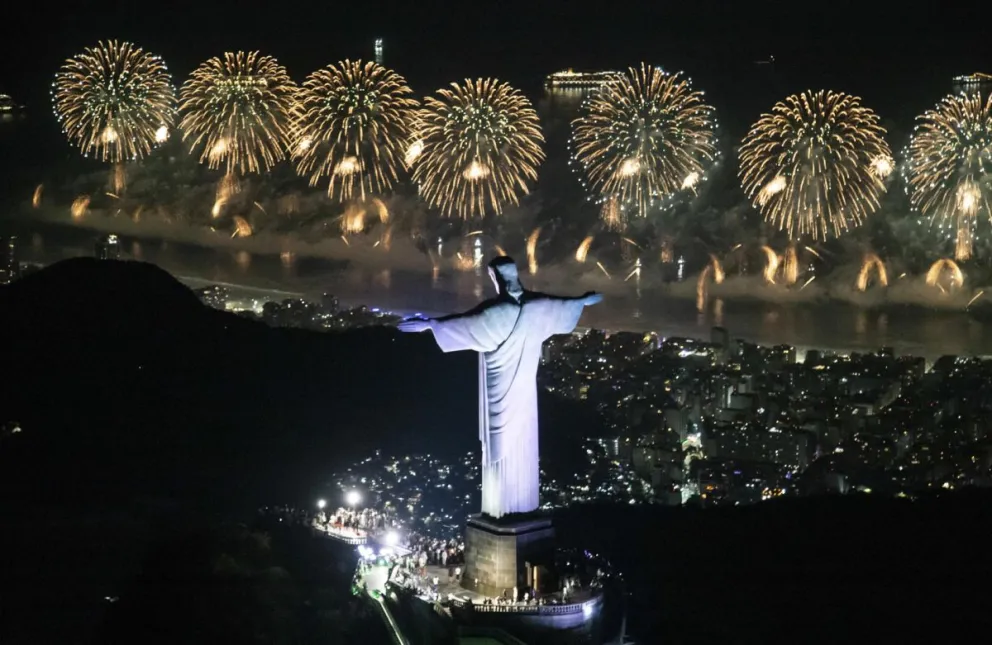 Fotografía cedida por la Alcaldía de Río de Janeiro que muestra el monumento del Cristo Redentor y fuegos artificiales sobre la playa de Copacabana este miércoles, en Río de Janeiro (Brasil). EFE