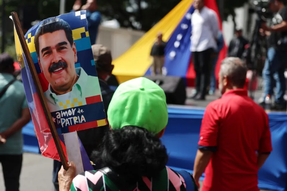 Una simpatizante del oficialismo sostiene un cartel con la imagen del presidente de Venezuela, Nicolás Maduro, este sábado en Caracas (Venezuela). Foto: EFE