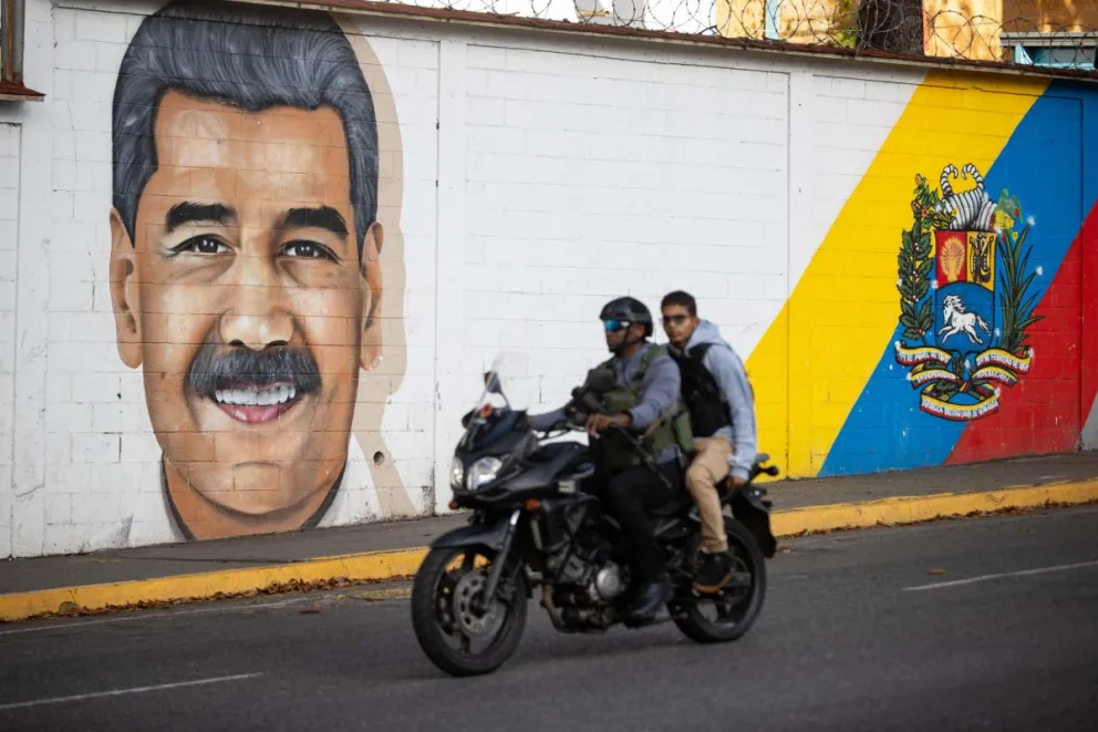 Personas transitan frente a un mural del presidente de Venezuela, Nicolás Maduro, este domingo en Caracas (Venezuela). Foto: EFE