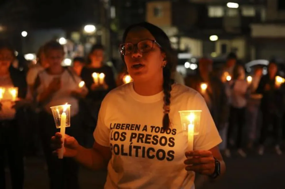 Una mujer sostiene velas durante una vigilia afuera del centro penitenciario Rodeo I este viernes, en el municipio Zamora estado Miranda (Venezuela). EFE/ STR
