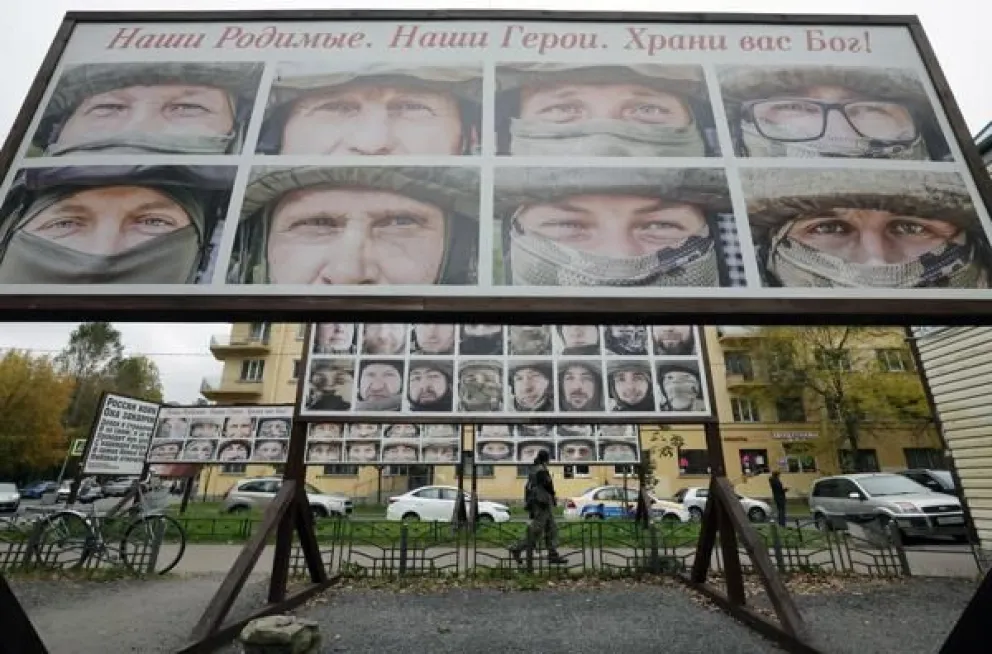 Varias personas pasan junto a retratos de soldados rusos que luchan en Ucrania, cerca de la oficina de un fondo de caridad que recauda donaciones para los combatientes rusos, en San Petersburgo, Rusia, en una imagen del 10 de octubre de 2025. EFE/EPA/ANAT