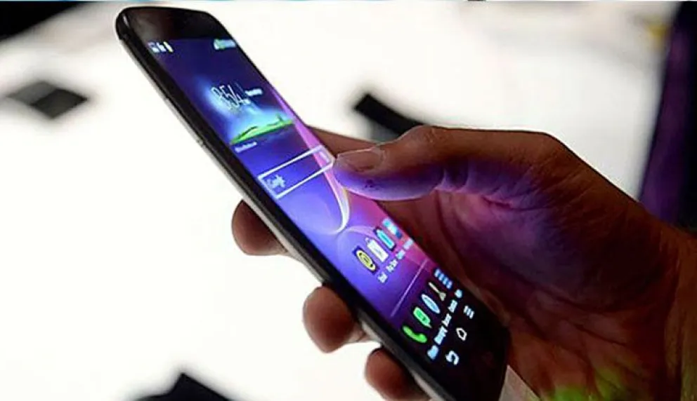 Un usuario con su teléfono celular en una imagen referencial. Foto: EFE 