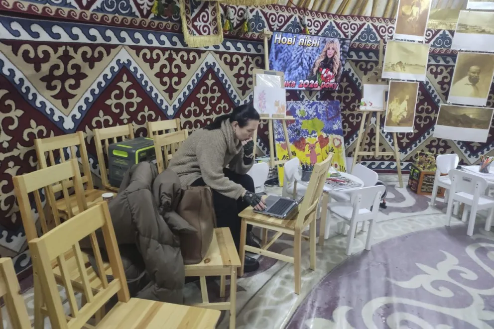 Una mujer trabaja con su ordenador portátil en una carpa. Foto: EFE 
