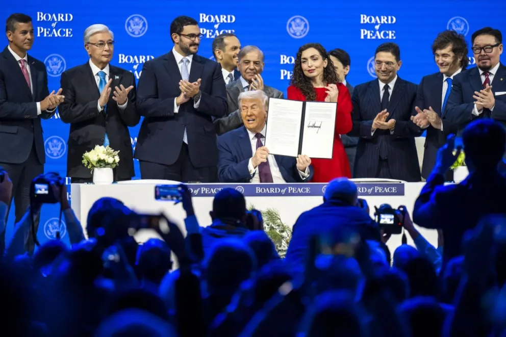 El presidente de Estados Unidos, Donald Trump, muestra la carta en la que se ha firmado la iniciativa Junta de Paz, rodeado de un grupo de líderes mundiales, durante la semana en la que se celebra el Foro de Davos. Foto: EFE