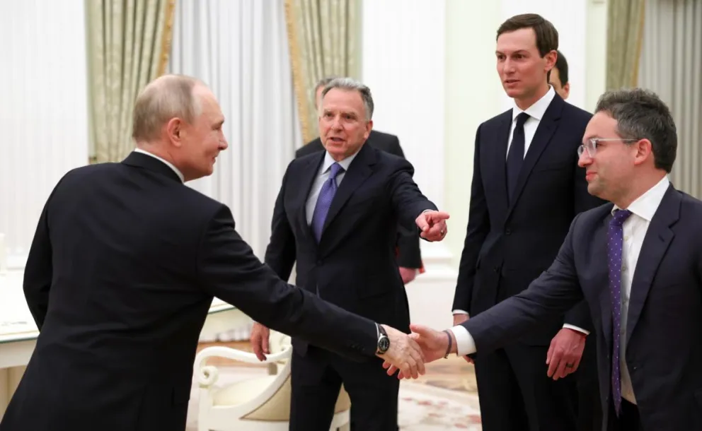 El presidente ruso, Vladímir Putin (d), estrecha la mano del comisionado del Servicio Federal de Adquisiciones de Estados Unidos, Josh Gruenbaum (d). Foto: EFE