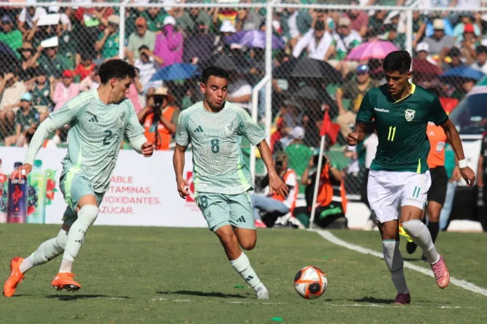 Fernando Nava (izq.), delantero de la selección boliviana, intenta superar la marca de dos jugadores mexicanos. Foto: APG