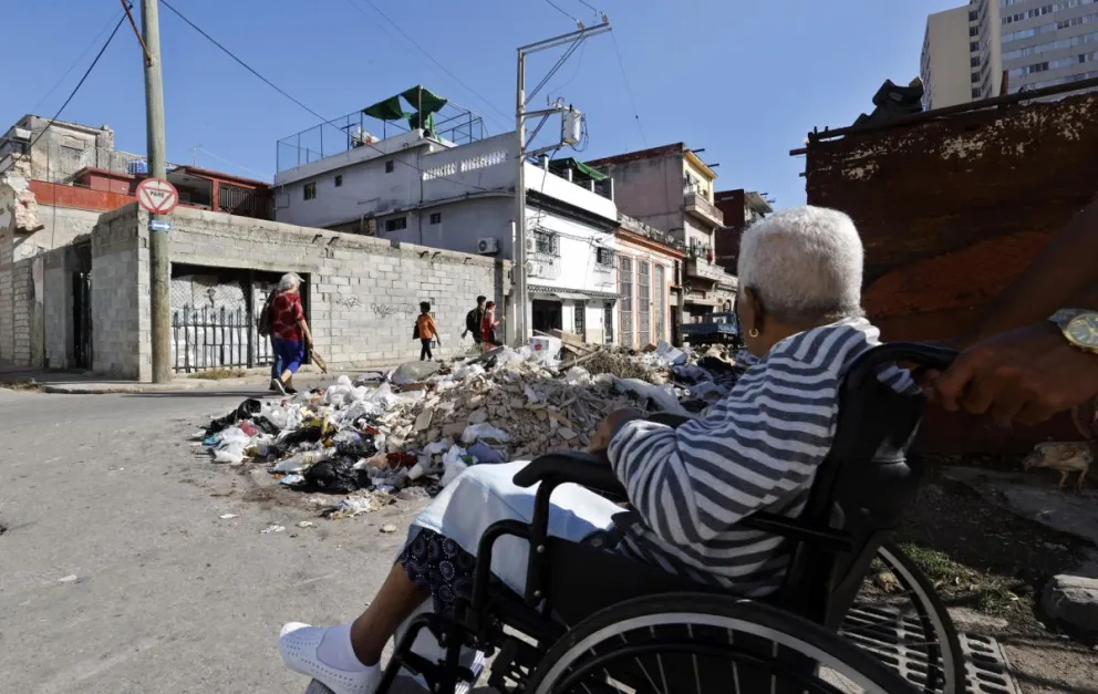 Fotografía del 22 de enero de 2026 que muestra un grupo de personas transitando por una calle con basura, en La Habana (Cuba). Foto: EFE