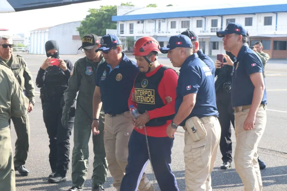 Fotografía cedida por la Fiscalía de Paraguay que muestra a Erick Moreno (c), alias 'El Monstruo', custodiado durante su extradición este miércoles, en Luque (Paraguay). Foto: EFE
