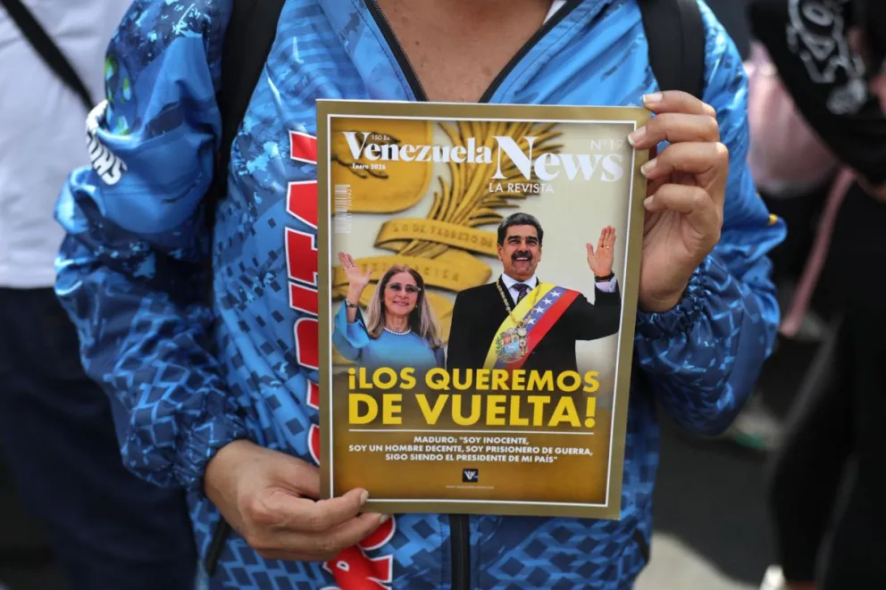Una persona sostiene un cartel con la imagen del presidente de Venezuela, Nicolás Maduro, y su esposa, Cilia Flores, durante una manifestación, en Caracas (Venezuela). Foto: EFE