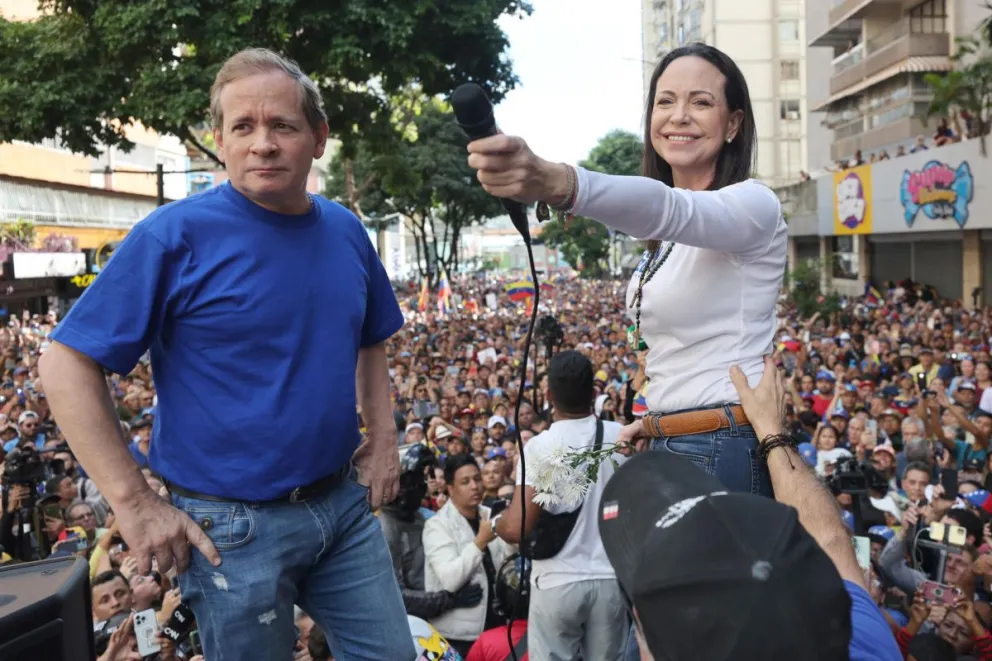 Fotografía de archivo fechada el 09 de enero de 2025 del exdiputado venezolano Juan Pablo Guanipa (i) junto a la líder antichavista María Corina Machado saludando a sus seguidores en una manifestación en Caracas (Venezuela).  Foto: EFE