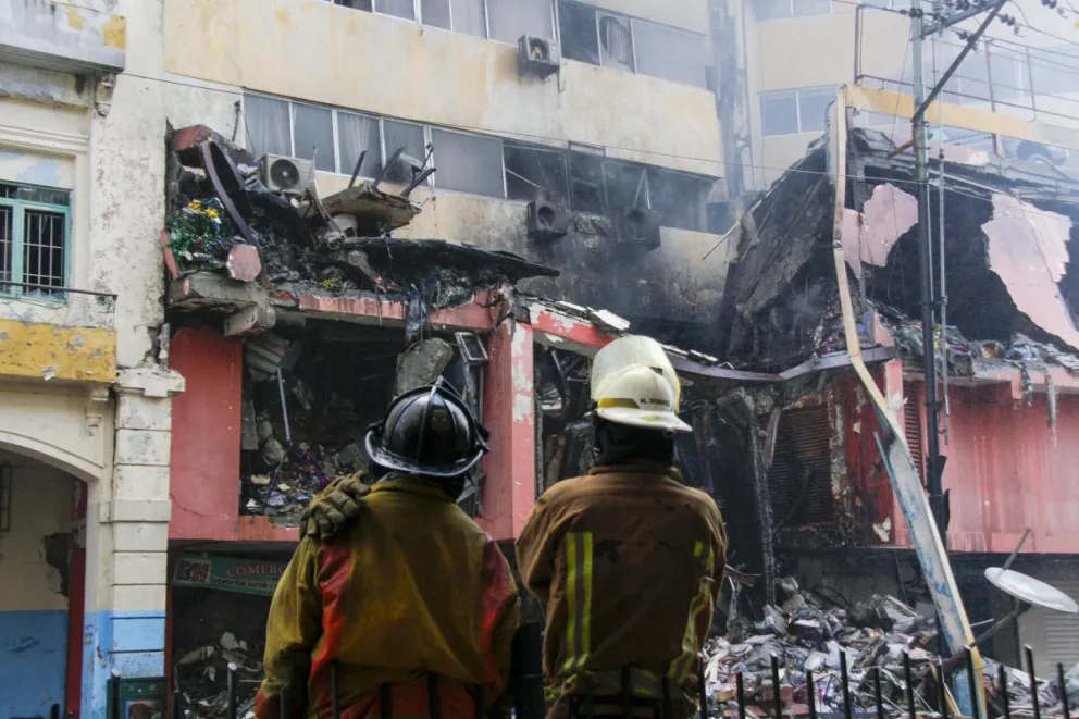 Integrantes del Cuerpo de Bomberos observan un edificio afectado por un incendio en Quito (Ecuador). Foto: EFE