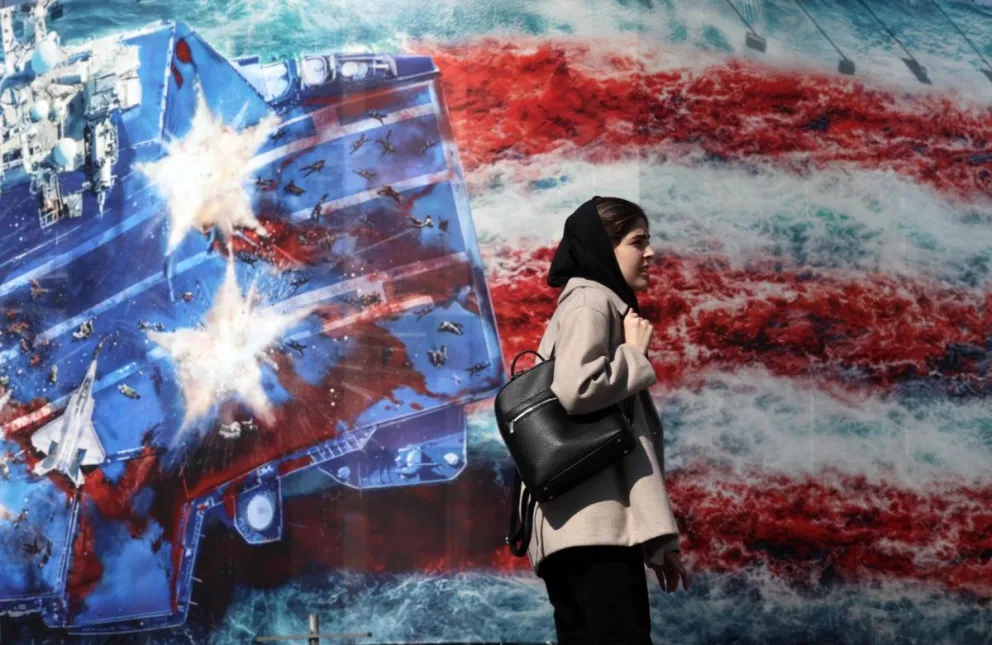 Una mujer pasa junto a una valla publicitaria antiestadounidense en la plaza Enqelab de Teherán, Irán, este lunes. Irán y EE. UU. celebrarán la segunda ronda de conversaciones el 17 de febrero de 2026 en Ginebra, Suiza. Foto: EFE