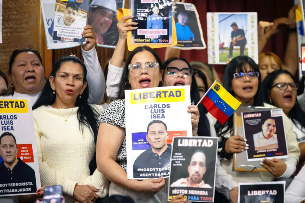 Personas sostienen carteles en una rueda de prensa este miércoles, en Caracas (Venezuela). Foto: EFE