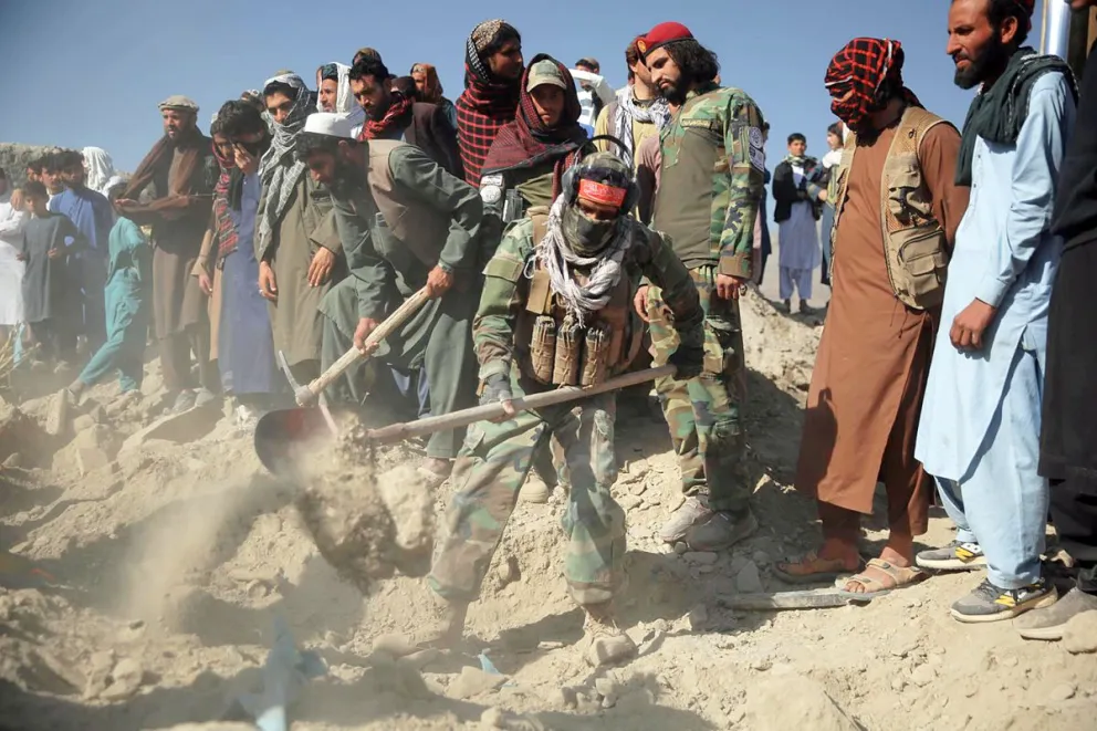 Personas enterrando a las victimas de los ataques en la región fronteriza de Afganistán. Foto: EFE