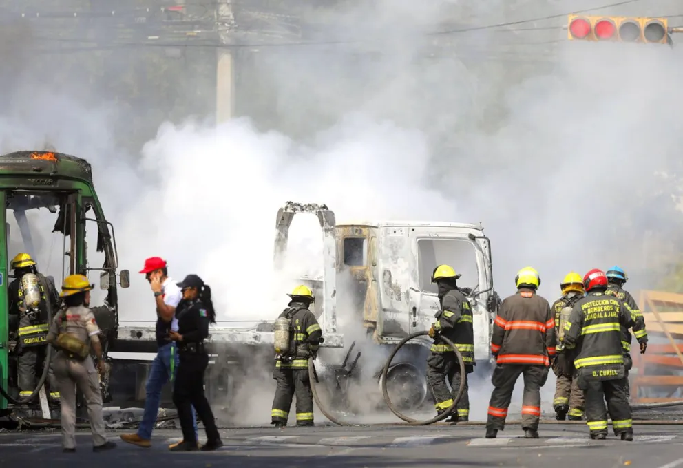 Bomberos de Guadalajara intentan apagar un vehículo incendiado este domingo, en Guadalajara (México). Foto: EFE