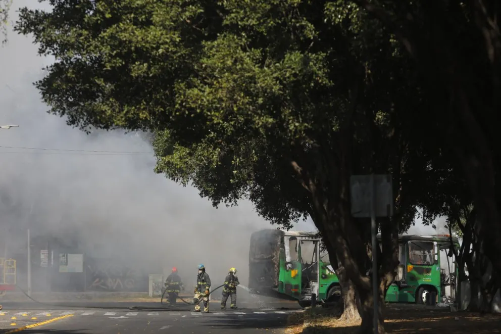 Integrantes del Cuerpo de Bomberos de Guadalajara intentan apagar un vehículo incendiado el pasado domingo, en Guadalajara (México). Foto: EFE